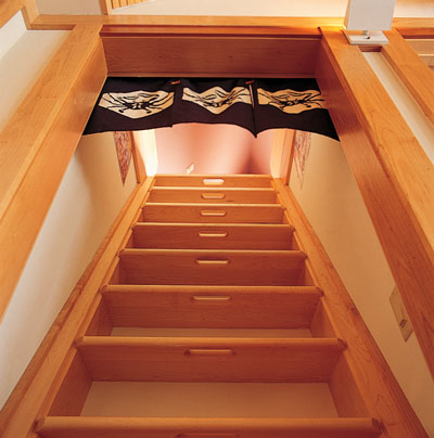 
A ship’s ladder, with hand holds cut into the steps, is a space-saving feature that leads to the attic meditation room.
